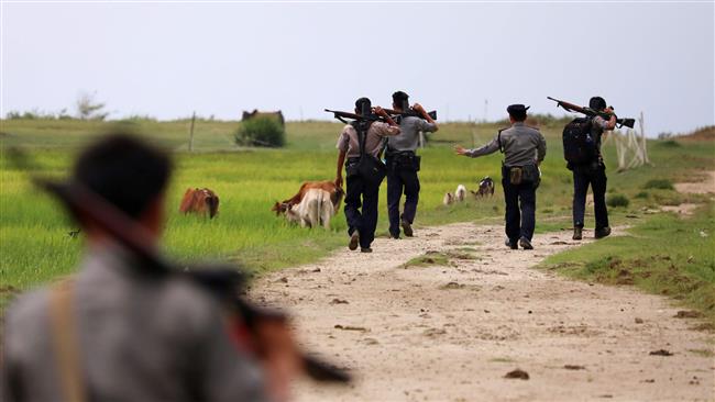 In this photo taken on September 7, 2017, armed Myanmar police patrol fields near Maungdaw in northern Rakhine State in northern Myanmar. (By AFP)
