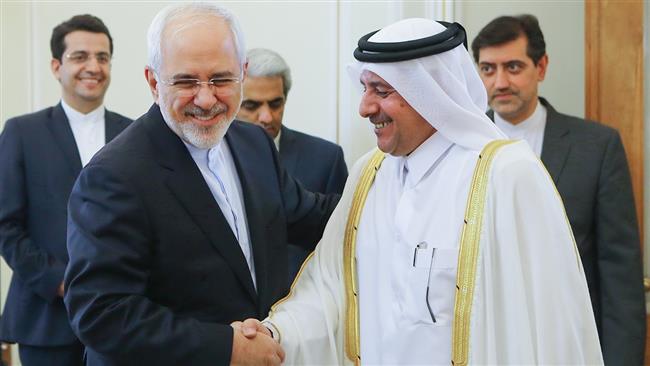 Iran’s Foreign Minister Mohammad Javad Zarif (L) shakes hands with Qatari Ambassador to Tehran Ali bin Ahmed Ali al-Sulaiti before a meeting in Tehran, on September 11, 2017.