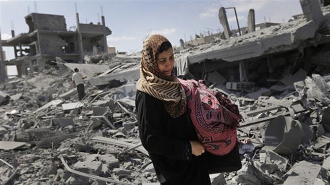 A Palestinian woman carries her belongings past the rubble of houses destroyed by Israeli strikes in Beit Hanoun, northern Gaza Strip, July 26, 2014.