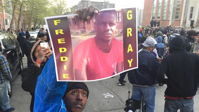 A protester holds a photo of Freddie Gray outside the Police Department in Baltimore in April 2015.
