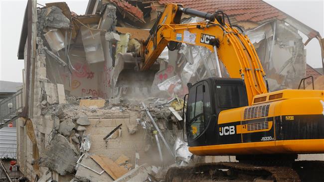 An Israeli bulldozer destroys a family house in the Israeli settlement of Ofra in the occupied West Bank on March 1, 2017. (Photo by AFP)