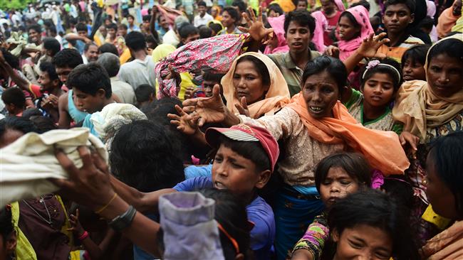 Newly arrived Rohingya refugees scuffle for relief supplies at Kutupalong camp in the Bangladeshi locality of Ukhia on September 9, 2017. (Photo by AFP)