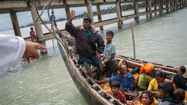 This photograph taken on September 12, 2017, shows Rohingya refugees arriving by boat at Shah Parir Dwip on the Bangladesh side of the Naf River after fleeing violence in Myanmar. (Photo by AFP)
