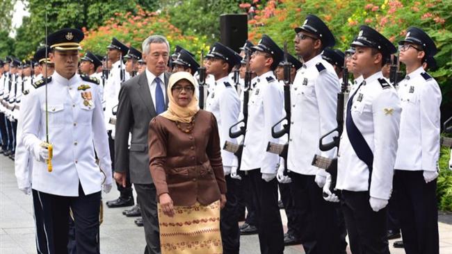 Halimah Yacob making her first inspection of the Guard of Honor, with PM Lee Hsien Loong walking right behind her.