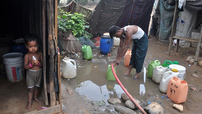 A Rohingya Muslim refugee from Myanmar fills water at a makeshift camp on the outskirts of the Indian city of Jammu, June 20, 2017. (Photo by AFP)