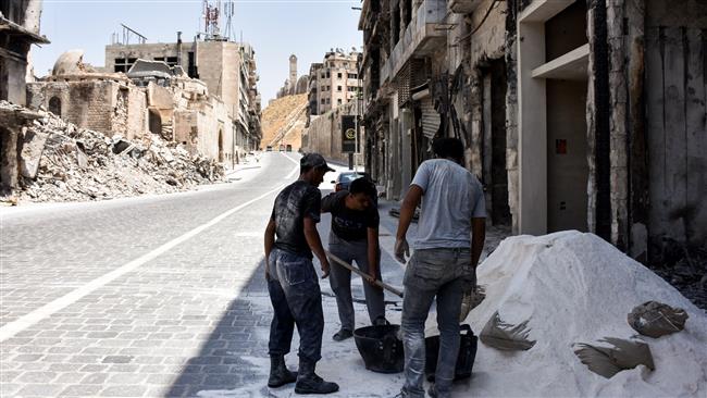 Syrian construction workers rebuild a damaged store in Khan al-Wazir market in Aleppo’s old city on July 22, 2017, after it was recaptured by government forces in December 2016. (Photo by AFP)