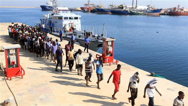 Refugees from Africa walk in line at a naval base in Tripoli after being rescued by Libyan coastguards in the Mediterranean Sea off the Libyan coast on August 29, 2017. (Photo by AFP)