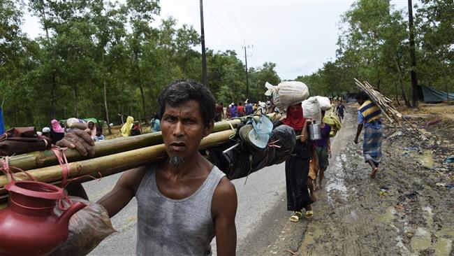 A Rohingya Muslim carries his belongings after being evicted with his family, while searching for a place to build a new makeshift shelter at the refugee camp of Kutupalung in the Bangladeshi locality of Ukhia on September 20, 2017. (AFP photo)