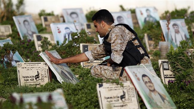 A Yemeni man touches the portrait of a loved one while squatting on top of his grave at a cemetery in the capital Sana’a on September 1, 2017. (Photo by AFP)