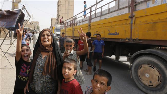 Syrians celebrate in the eastern city of Dayr al-Zawr on September 20, 2017 as an Iranian humanitarian aid convoy arrives in the city after its liberation from Daesh Takfiri terrorists. (Photo by AFP)