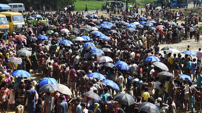Rohingya refugees wait in line for food to be distributed at the Balukhali refugee camp near Gumdhum on September 25, 2017. (Photo by AFP)