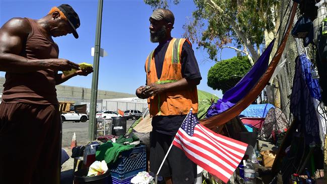 Two homeless military veterans look over some citations they recently received outside their tent on a street corner near Skid Row in downtown Los Angeles, California on June 20, 2017. (AFP photo)