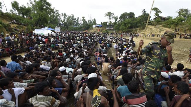 Rohingya Muslim refugees wait as food is distributed by the Bangladeshi army at Balukhali refugee camp near Gumdhum on September 26, 2017. (Photo by AFP)