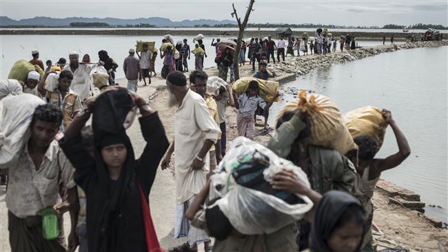 Rohingya Muslim refugees walk toward refugee camps after crossing the border from Myanmar at the Bangladeshi shores of the Naf River in Teknaf on October 5, 2017. (Photo by AFP)