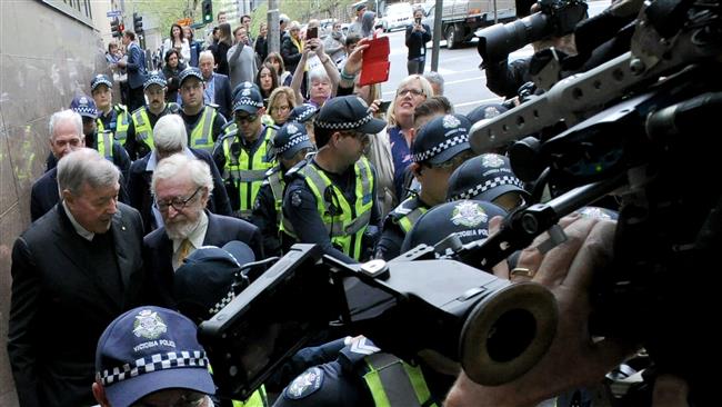 Cardinal George Pell (L) walks after his committal hearing related to charges of historical sex abuse at the Melbourne Magistrates Court on October 6, 2017. (Photo by AFP)