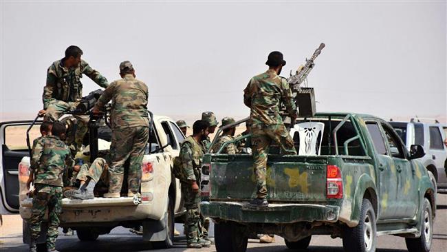 This photo released on Monday, September 4, 2017 by SANA, shows Syrian troops and pro-government fighters standing on pickup trucks near Dayr al-Zawr. (Via AP)