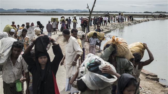 Rohingya Muslim refugees walk toward camps after crossing the border from Myanmar at the Bangladeshi shores of the Naf river in Teknaf, October 5, 2017. (Photo by AFP)