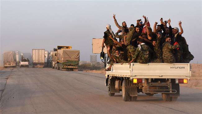 Syrian pro-government forces flash the sign for victory in the back of vehicle on the outskirts of the eastern city of Dayr al-Zawr on September 10, 2017. (Photo by AFP)