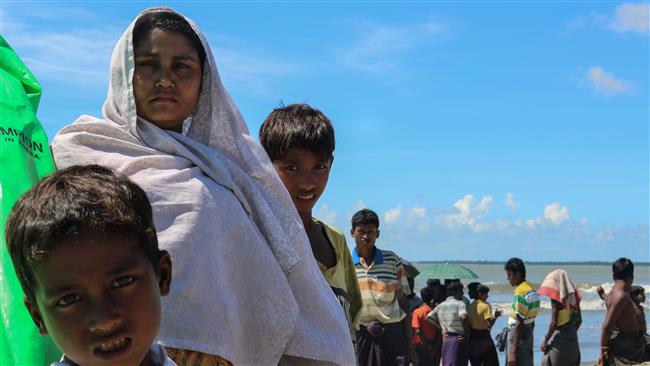 This photo taken on October 10, 2017 shows fleeing Rohingya Muslims waiting to cross the border into Bangladesh at the banks of Gaw Du Thar Ya village in Maungdaw, Northern Rakhine State. (Photo by AFP)