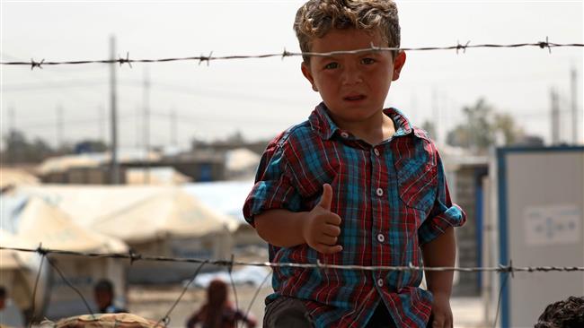 A displaced Iraqi boy, who fled the fighting in the region of Mosul, gestures to the camera at the Debaga camp, east of Makhmur in northern Iraq, on August 17, 2017. (Photo by AFP)