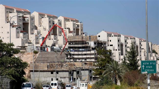 This file photo shows construction workers building new units in the Israeli settlement of Kiryat Arbaon on the outskirts of the occupied West Bank city of al-Khalil. (Photo by AFP)