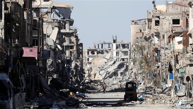 A member of the US-backed Syrian Democratic Forces (SDF) stands amidst the ruins of buildings near the Clock Square in Raqqah, Syria, October 18, 2017. (Photo by Reuters)