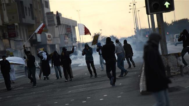 Bahraini protesters run for cover from tear gas during clashes with riot police in the village of Sitra, January 29, 2016. (Photo by AFP)