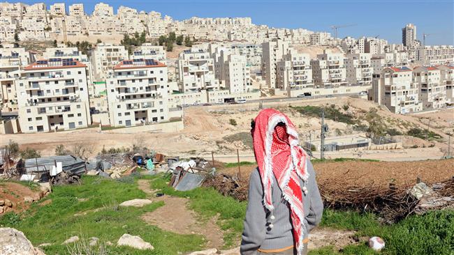 A Palestinian man looks at an Israeli settlement in occupied Jerusalem al-Quds. (File photo)