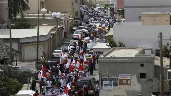 Bahraini anti-government protesters wave national flags and hold up images of jailed political leaders during a protest after midday prayers in Diraz, Bahrain, May 8, 2015. (Photo by AP)