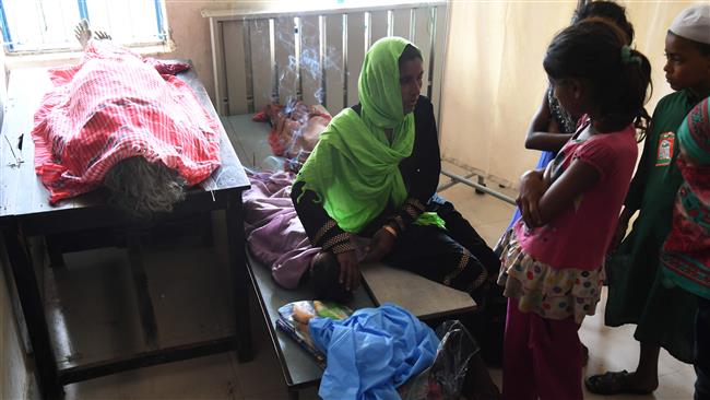 A Rohingya Muslim refugee reacts as she sits alongside the body of her daughter, 4, who died in a boat accident while trying to reach Bangladesh, at the Bahar Chara government medical center near Teknaf, in Bangladesh, on October 31, 2017. (Photo by AFP)