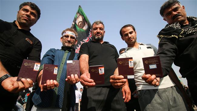 Iranian pilgrims show their passports as they pass through the Shalamcheh border crossing into Iraq on October 28, 2017, making their way to the holy Iraqi city of Karbala to take part in the Arba’een religious rituals. (Photo by AFP)