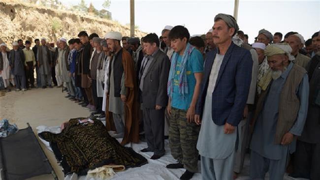 Afghan Shia mourners and relatives pray in front of the coffin of one of 26 victims killed in a car bombing in Kabul on July 25, 2017. (Photo by AFP)