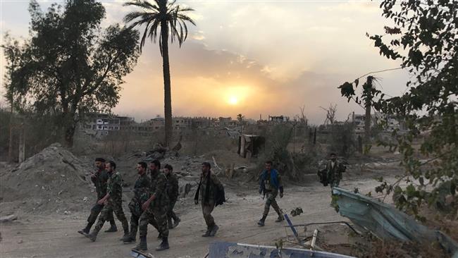 Syrian government forces walk through a road in a northeastern district of Dayr al-Zawr on November 5, 2017, after retaking the city from Daesh Takfiri terrorists. (Photos by AFP)