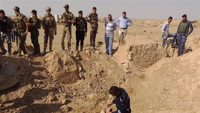 Iraqi forces search the site of a suspected mass grave containing the remains of victims of Daesh Takfiri terrorists, near the former al-Bakara military base, southwest of Hawijah, November 11, 2017. (Photo by AFP)