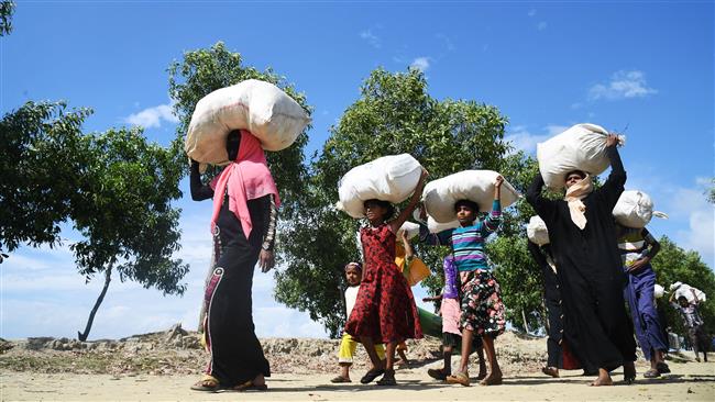 Rohingya Muslim refugees who entered Bangladesh by makeshift boats walk towards refugee camps after landing at Sabrang in the Teknaf district of Bangladesh on November 11, 2017. (Photo by AFP)