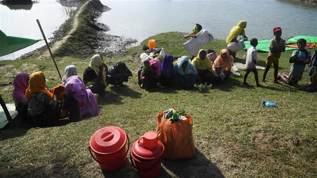 Rohingya Muslim refugees rest after sailing to cross the Naf River and enter Bangladesh at Sabrang, Teknaf district, November 11, 2017. (Photo by AFP)