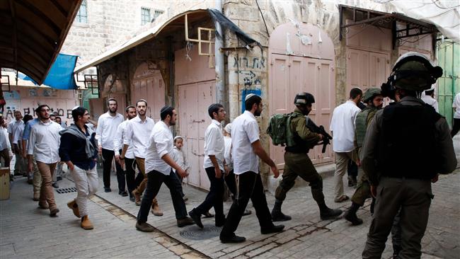 Israeli settlers and religious students are escorted by Israeli security forces during a tour of the Israeli-occupied West Bank city of al-Khalil (Hebron) on November 18, 2017. (Photo by AFP)