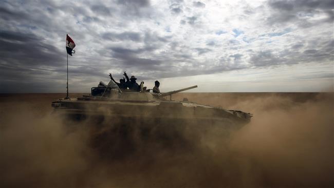 Iraqi troops flash the victory gesture from an advancing armored personnel carrier as they advance through Anbar province, 20 kilometers east of the city of Rawah in the western desert bordering Syria, on November 25, 2017. (Photos by AFP)