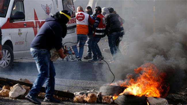 Palestinian paramedic volunteers carry away an injured protester into an ambulance during clashes between Palestinian protesters and Israeli forces in the West Bank city of Ramallah on December 12, 2017. (AFP photo)