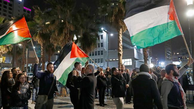 Israeli protesters wave Palestinian flags during a demonstration in front the American embassy in Tel Aviv on December 12, 2017 against the US and Israel. (Photo by AFP)