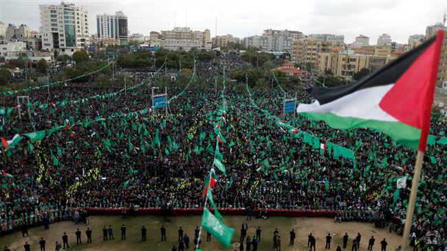 A Palestinian flag flies as Hamas supporters take part in a rally marking the 30th anniversary of the movement