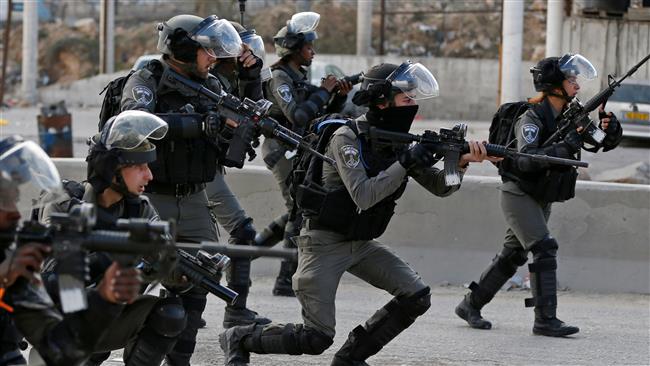 Israeli forces take aim as Palestinian protestors gather near the West Bank checkpoint of Qalandia, on the outskirts of Ramallah, on December 15, 2017. (Photo by AFP)