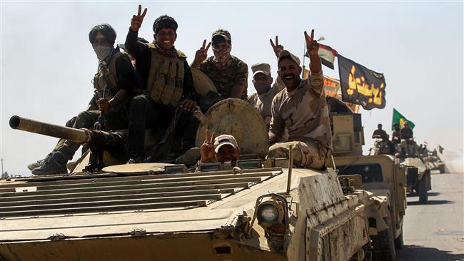 Members of the Popular Mobilization Units (PMU), better known as Hashd al-Sha’abi, flash the victory gesture as they ride atop an infantry-fighting vehicle during their advance towards villages between the northern Iraqi cities of Hawijah and Kirkuk on October 6, 2017. (Photo by AFP)