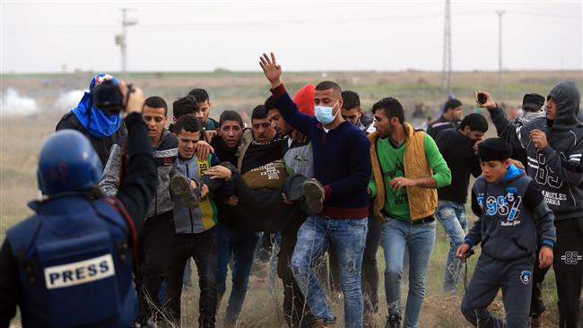 Palestinian protesters carry a wounded comrade during clashes with Israeli soldiers near the border fence east of Gaza City on December 22, 2017. (Photo by AFP)