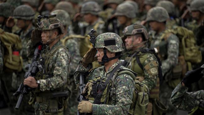 Philippine soldiers salute as they arrives at the port of Manila on October 30, 2017, with some 500 personnel composed of marines, sailors, aviators and intelligence operative after a five-month deployment in Marawi City. (Photo by AFP)