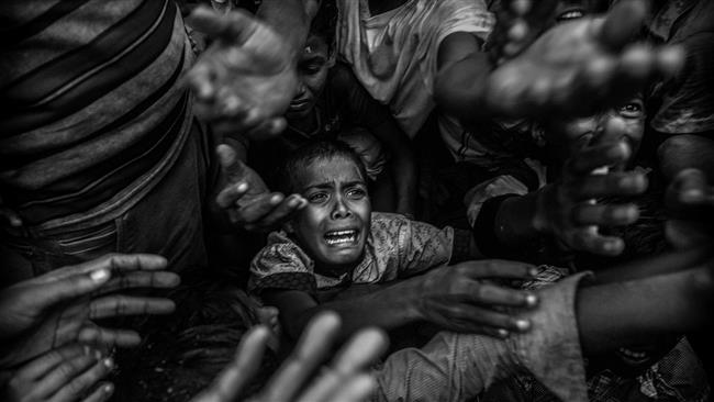 The photo taken on September 18, 2017 near Cox’s Bazaar shows a Rohingya refugee child in a crowd that fled to Bangladesh from violence and persecution in Myanmar.