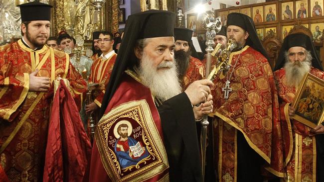 Jerusalem al-Quds’ Greek Orthodox Patriarch Theophilos III (C) attends a Christmas service in the church of Nativity in the Israel-occupied West Bank town of Bethlehem on January 6, 2018. (Photo by AFP)
