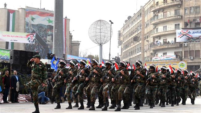 Syrian government soldiers march in formation during a rally celebrating the retaking of the northern Syrian city of Aleppo, in its square of Saadallah al-Jabiri on December 21, 2017. (Photo by AFP)