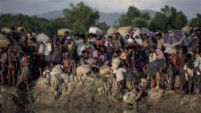 The photo taken on October 9, 2017 shows Rohingya Muslim refugees waiting after crossing the Naf river from Myanmar into Bangladesh in Whaikhyang. (Photo by AFP)