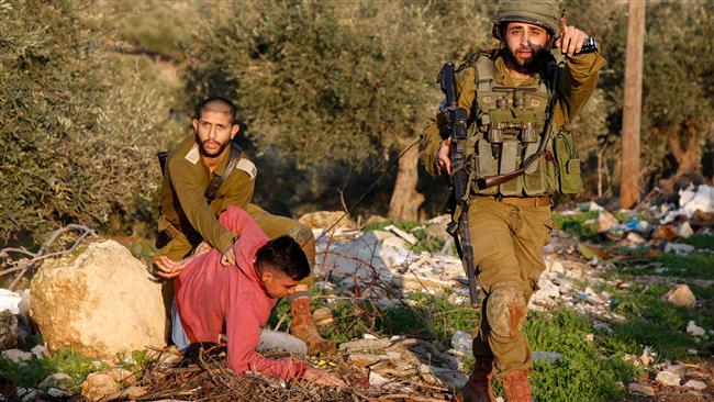 Israeli soldiers detain a Palestinian youth during clashes east of the occupied West Bank village of Salem near Elon Moreh settlement on January 7, 2018. (Photo by AFP)